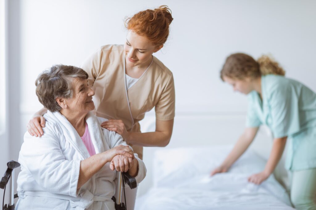 Seniorin im Rollator betreut von weiblicher Pflegefachkraft von ambulantem Pflegedienst